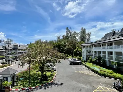 arial view of a parking lot in front of a building at Allamanda Laguna Phuket by RESAVA in Bang Tao Beach