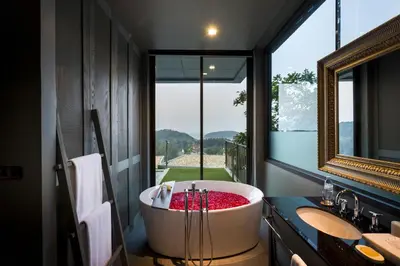 a large bath tub in a bathroom with a window at SUNSURI PHUKET, Nai Harn Beach in Nai Harn Beach