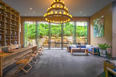 a large lobby with a large window and a chandelier at SUNSURI PHUKET, Nai Harn Beach in Nai Harn Beach