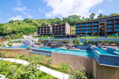 a resort with a swimming pool and some buildings at SUNSURI PHUKET, Nai Harn Beach in Nai Harn Beach