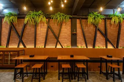 a restaurant with wooden tables and plants on the wall at The Z Nite Hostel in Phuket Town