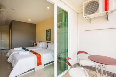 a bedroom with a bed and a table and chairs at Central Residences in Phuket Town