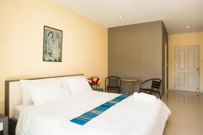 a bedroom with a bed and a table and chairs at Central Residences in Phuket Town