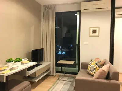 a living room with a couch and a table and a television at Zcape at Bangtao in Bang Tao Beach