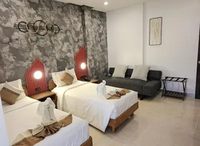 a hotel room with two beds and a couch at U Sabai Living Hotel in Patong Beach