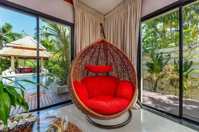 a red chair in a room with windows at VILLA TOBA Pool Baan Bua Estate Naiharn beach in Nai Harn Beach