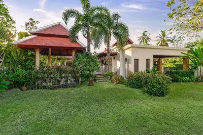 a house with a grass yard in front of it at VILLA TOBA Pool Baan Bua Estate Naiharn beach in Nai Harn Beach