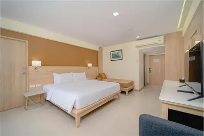 a bedroom with a large white bed and a television at Aonang Buri Resort in Ao Nang Beach