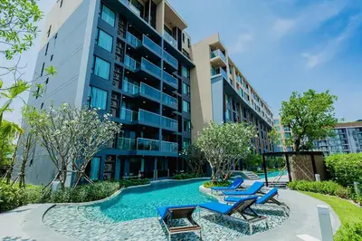 a swimming pool with lounge chairs in front of a building at The Aristo by Holy Cow, 2-BR, 60 m2, pool view in Surin Beach