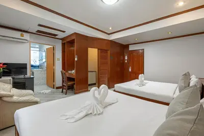 a bedroom with two beds and a living room at Break Point Patong Hotel in Patong Beach