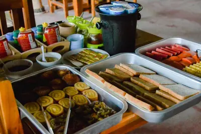 a table with two trays of different types of food at Baan Tubkaek Hotel in Tab Kaek Beach