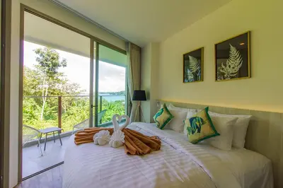 a bedroom with a bed with a large window at Oceana Sea View Apartments - Kamala Beach in Kamala Beach