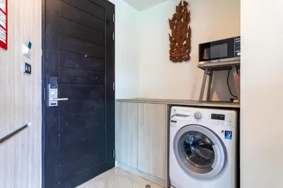 a washing machine in a room with a black door at Oceana Sea View Apartments - Kamala Beach in Kamala Beach
