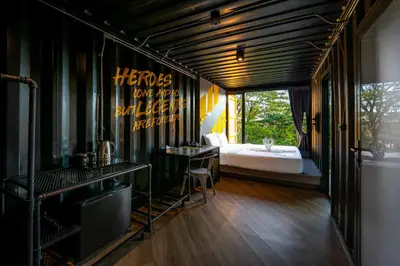 a bedroom with a bed and a desk and a bed sidx sidx sidx at Hivetel Phuket in Chalong