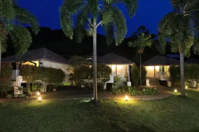 a resort at night with palm trees and lights at Daydream villa resort in Patong Beach