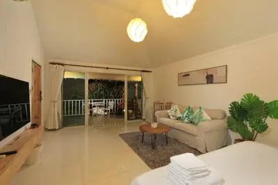 a living room with a couch and a television at Daydream villa resort in Patong Beach