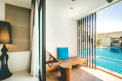 a room with a chair and a swimming pool at The Pago Design Hotel Phuket-SHA Plus in Phuket Town