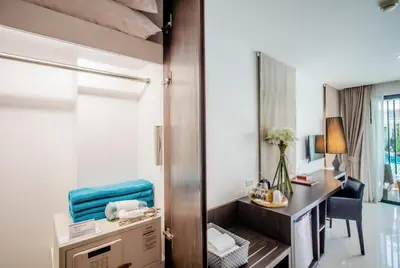 a hotel room with a desk and a mirror at The Pago Design Hotel Phuket-SHA Plus in Phuket Town