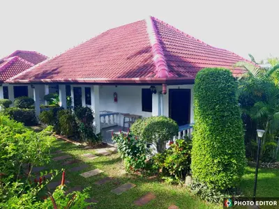 a white house with a red roof at D&K Smiley Phuket Resort in Rawai Beach
