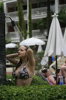 a woman in a bathing suit with a water hose at Sunset Beach Resort in Patong Beach