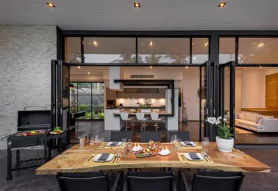 a dining room with a large wooden table with chairs at Braya Villa in Ko Yao Yai