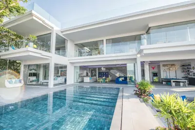 an exterior view of a house with a swimming pool at Villa Enjoy Phuket in Patong Beach