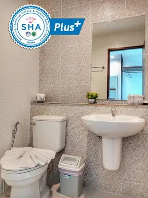 a bathroom with a toilet and a sink and a mirror at Louis' Runway View Hotel - SHA Extra Plus in Nai Yang Beach
