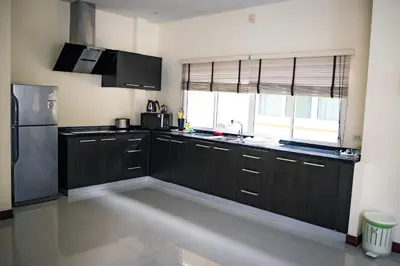 a kitchen with black cabinets and a stainless steel refrigerator at Villa Tanya, 3 Bed with Private Pool and Jacuzzi in Rawai Beach