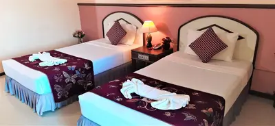 two beds in a hotel room with towels on them at La Moon At Phuket - SHA Extra Plus in Phuket Town