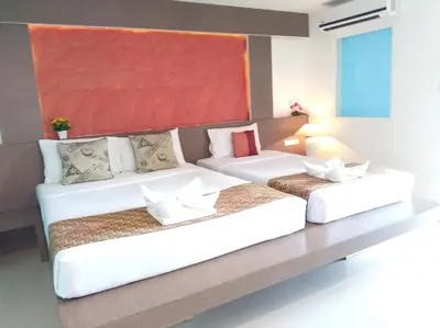 two beds in a hotel room with at La Moon At Phuket - SHA Extra Plus in Phuket Town