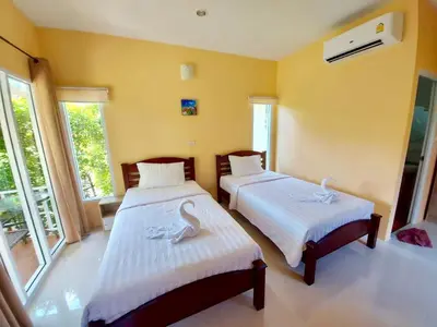 a bedroom with two beds with swans on them at Koh Yao Modern Inn -SHA Plus in Ko Yao Yai