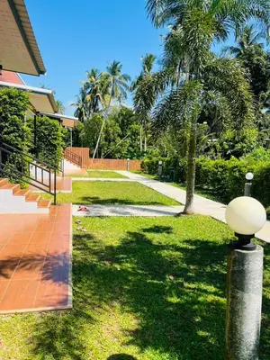 a walkway in front of a house with palm trees at Koh Yao Modern Inn -SHA Plus in Ko Yao Yai