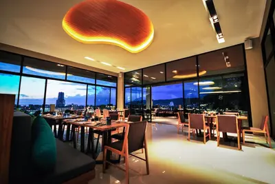 a restaurant with tables and chairs with a view of the city at The Senses Resort & Pool Villas, PHUKET in Patong Beach