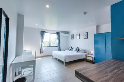 a bedroom with a bed and a sink in a room at Maikhao Hotel, Phuket in Mai Khao Beach