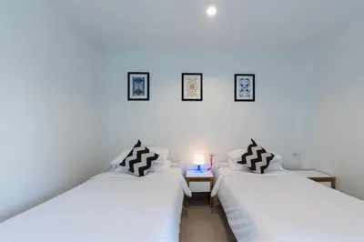 two beds sitting next to each other in a room at Maikhao Hotel, Phuket in Mai Khao Beach