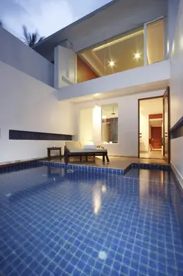 a swimming pool in the middle of a house at La Flora Resort Patong in Patong Beach