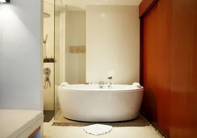 a white bath tub in a bathroom with a shower at La Flora Resort Patong in Patong Beach