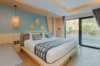 a bedroom with a large bed and a large window at Baan Taranya Koh Yao Yai Resort in Ko Yao Yai