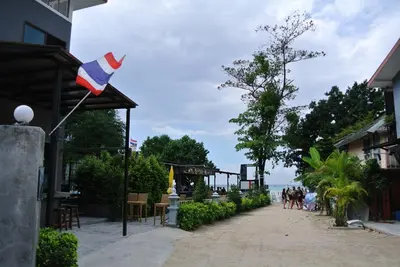 a flag on a building with people walking down a street at Ibiza House Phi Phi in Phi Phi Don