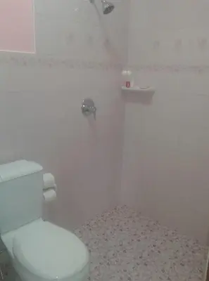 a white bathroom with a toilet and a sink at Majestic Villas Guesthouse Phuket. in Rawai Beach