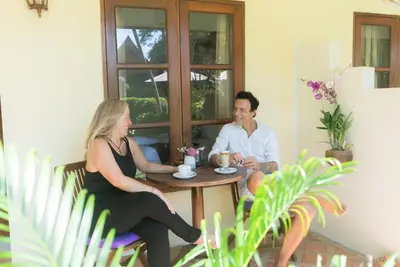 a man and a woman sitting at a table at Palm Garden Resort in Rawai Beach