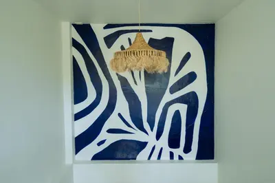 a painting with a hat hanging on a wall at Phuket Boat Quay Hotel Panwa Beach in Panwa Beach