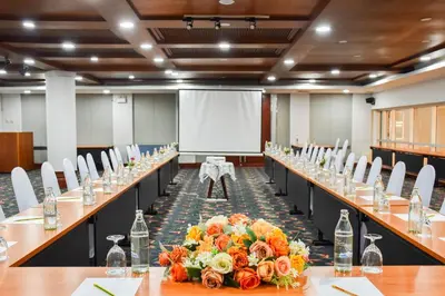 a conference room with long tables with flowers and bottles at Phuket Merlin Hotel in Phuket Town