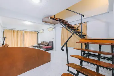a living room with a spiral staircase in a house at Royal Prince Residence, Patong Beach in Patong Beach
