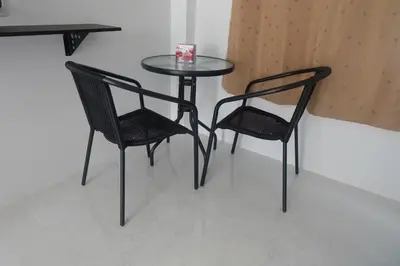two black chairs and a table and a table and chairs at Airport Pearl Residence in Nai Yang Beach