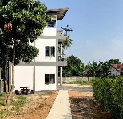 a white house with a tree in front of it at Airport Pearl Residence in Nai Yang Beach