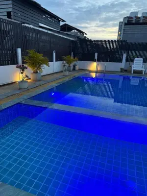 a swimming pool with blue lighting on a building at EX-IT Inn in Patong Beach