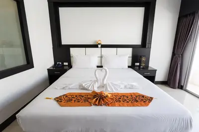 a bedroom with a white bed with a towel on it at EX-IT Inn in Patong Beach