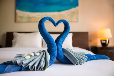 two towels shaped like swans sitting on a bed at Luxurious SeaView 4br Private Pool Villa by Intira Villas in Rawai Beach