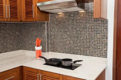a kitchen counter with a stove with pots and pans at Villa Bang Tao 3 Bedroom Q Kata Residence in Bang Tao Beach